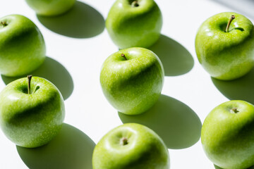 close up of green tasty apples on white. - obrazy, fototapety, plakaty