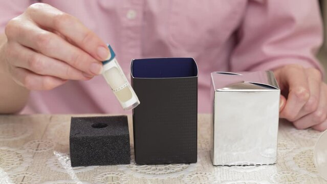 woman puts a saliva container for dna test in a shipping box