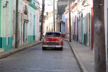 Street with its colorful houses and one old car in the middle, Camaguey, Cuba