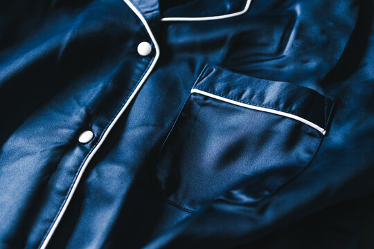 luxurious navy blue silk or satin tailored pyjama detail, fabric close-up with soft wrinkles