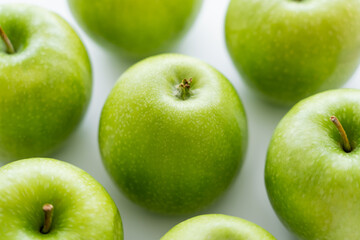 close up of delicious green apples on white.