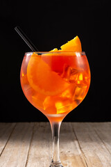Glass of aperol spritz cocktail on black background. Close up
