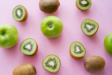 Fototapeta premium top view of green apples and kiwi on pink.