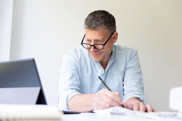 Fototapeta premium Business portrait of architect sitting at his work table and planning in his modern bright office