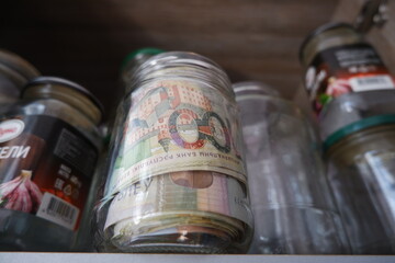 The money is in a glass jar. Savings.