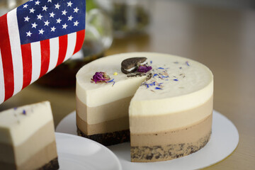 Beautiful delicious cake with cookies and flowers on a white plate, copy space and usa flag on the...