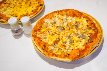 Piece of the pizza on wooden tray to divided pieces,Pizza is italian food with small bottle sault and pepper, the kind of food that fits into today's life style.