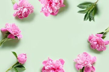 Fototapeta na wymiar Frame of pink peony flowers on green background. Greeting card for Mother day.