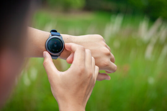 Smart watch. Smart watch on the hands of an outdoor man Man's hand touching watch . Close-up shot of using a digital watch to measure heart rate outdoors.