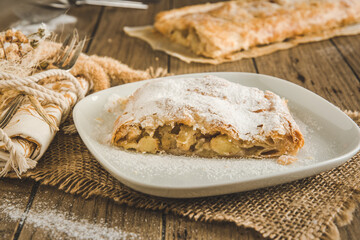 Traditional homemade apple strudel on a rustic wooden table