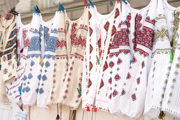 Variety of ethnic ukrainian traditional embroidered shirts, vyshyvanka - traditional embroidered clothes on flea market or national festival. Vintage goods on flea market. Symbol of Ukrainian culture