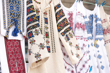 Ethnic ukrainian traditional clothes, vyshyvanka - traditional embroidered shirts on flea market or national festival. Vintage goods on flea market, ukrainian culture and customs