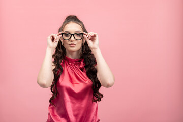 Portrait of attractive businesswoman friendly smiling, responsible, wearing jacket, eyeglasses isolated on pink background.