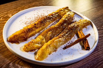 fried bananas in sugar syrup and cocoa with cinnamon