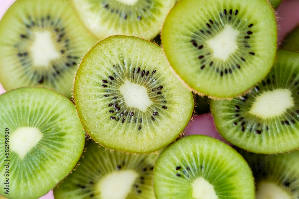 Poster top view of sliced fresh kiwi on pink, close up.