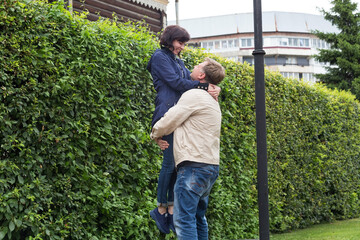 The blond man raised the laughing woman above his head, the concept of a couple in love.