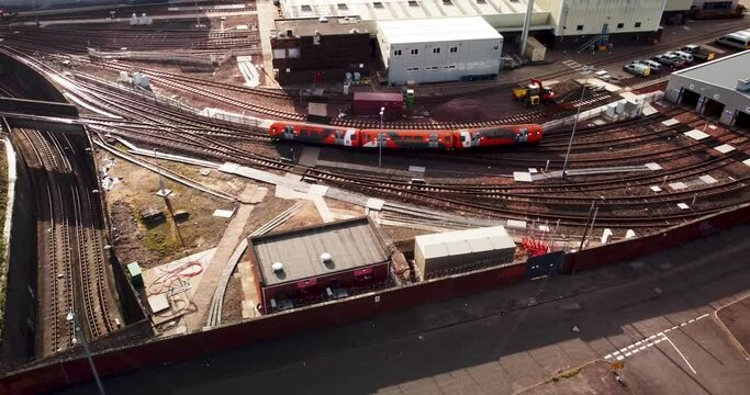 Glasgow Subway train over ground entering service depot in Govan, aerial shot 4k