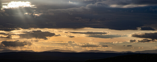 amazing sunset sky over green hills in early summer