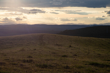 amazing sunset sky over green hills in early summer
