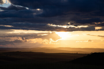 amazing sunset sky over green hills in early summer