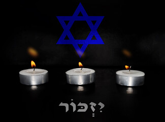 Burning candles with background blurred Jewish star (Magen David) and blurred Hebrew text...