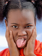 Girl with pigtails sticking out tongue, ten years old, close-up portrait, photo 