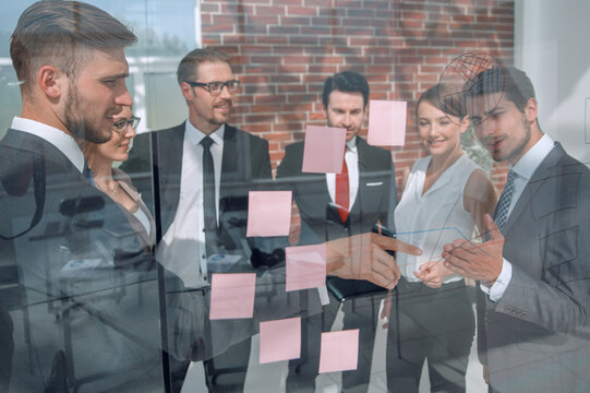business team showing on the notes on the glass Board