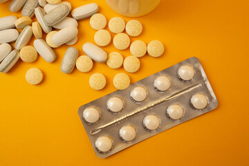 White pills on a yellow background, medical theme