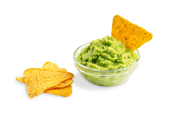 Fresh homemade vegetarian guacamole mexican dip, sauce or salad made of mashed ripe raw avocado served in glass bowl with crispy tortilla chips or nachos as healthy snack isolated on white background