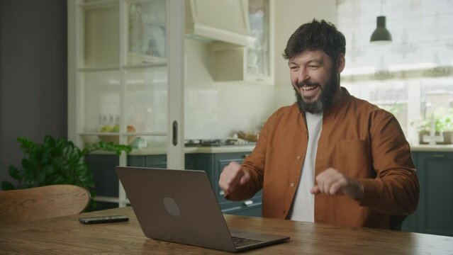 Portrait of a young adult caucasian man recieving good news on his laptop