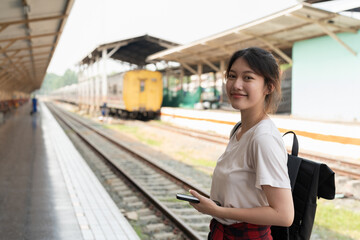 Portrait young asian woman backpacker travel at train station.
