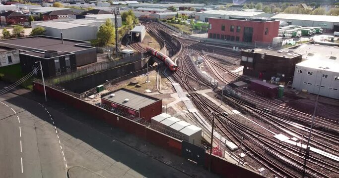 Glasgow Subway train over ground entering service depot in Govan, aerial shot 4k