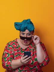 Blonde plus size woman having conversation talking by smartphone over yellow background smiling with an idea or question pointing finger with happy face, number one