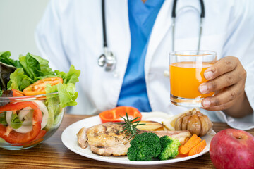 Nutritionist doctor with various healthy fresh vegetables for patient.