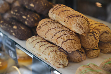Freshly baked Eclairs in the showcase of a pastry shop close-up. Focus on the middle ground