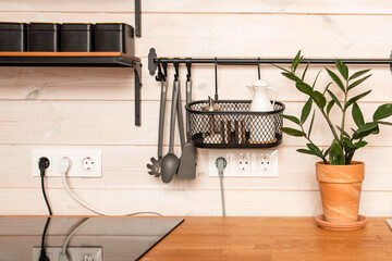 Kitchen brass utensils, chef accessories. Hanging kitchen with white tiles wall and wood tabletop.Kitchen background copy space 