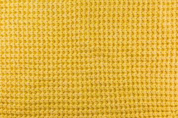 Surface of yellow wool sweater as background, texture, pattern.
