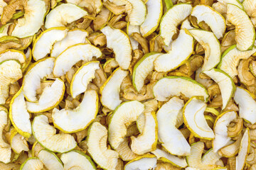 The background is formed by a large number of sliced and dried slices of apples, dried fruits.