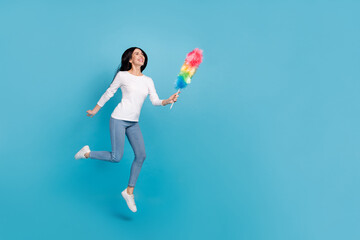 Fototapeta na wymiar Full length body size view of attractive cheery dreamy girl maid jumping using brush copy space isolated on bright blue color background