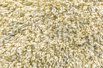 The texture is formed by the light yellow carpet villi as a background.