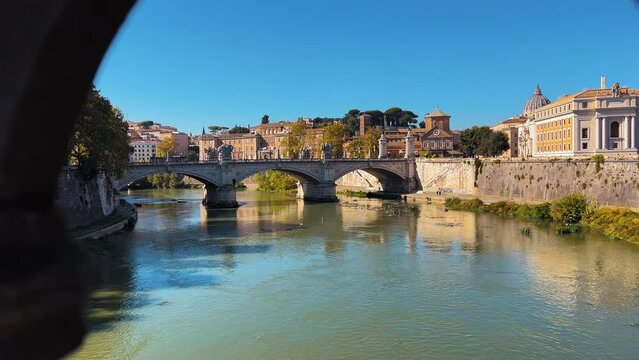 Dolly forward shot showing Tiber River and Angelo Bridge in Rome during summer day