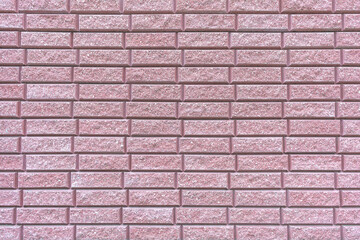 The background is formed by a wall covered with decorative tiles that mimic a brick wall.