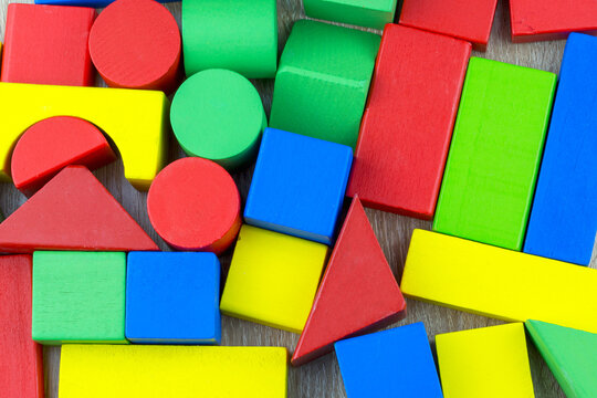 Multicolored children's wooden cubes as a background, texture, pattern. Multicolored wooden elements of various shapes. - Powered by Adobe