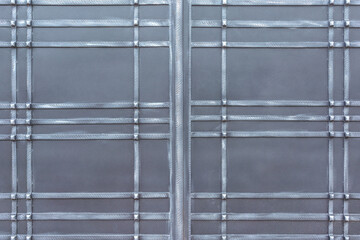 A sheet of metal to which metal strips are soldered, which intersect to form rectangles and squares of different shapes as a background, texture, pattern.