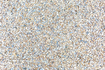 The surface is covered with a large number of very small colored stones, as a background, texture, pattern.