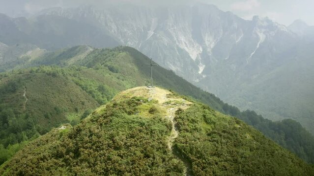 Path to faith and spirituality with cross on hilltop in magnificent apuane landscape