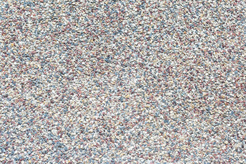 The surface is covered with a large number of very small colored stones, as a background, texture, pattern.