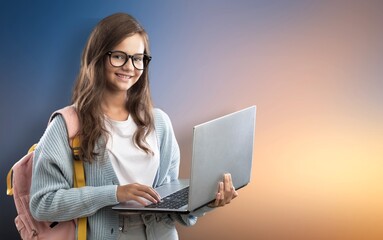 Portrait of smiling teen girl using a laptop computer, studying online
