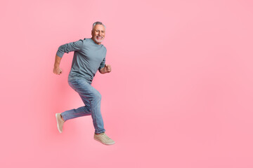 Fototapeta na wymiar Full length body size view of attractive cheery motivated grey-haired man jumping running isolated over pink pastel color background
