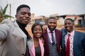 A group of friends take a selfie together, well-dressed African young adults in the city center, African Sapologie.